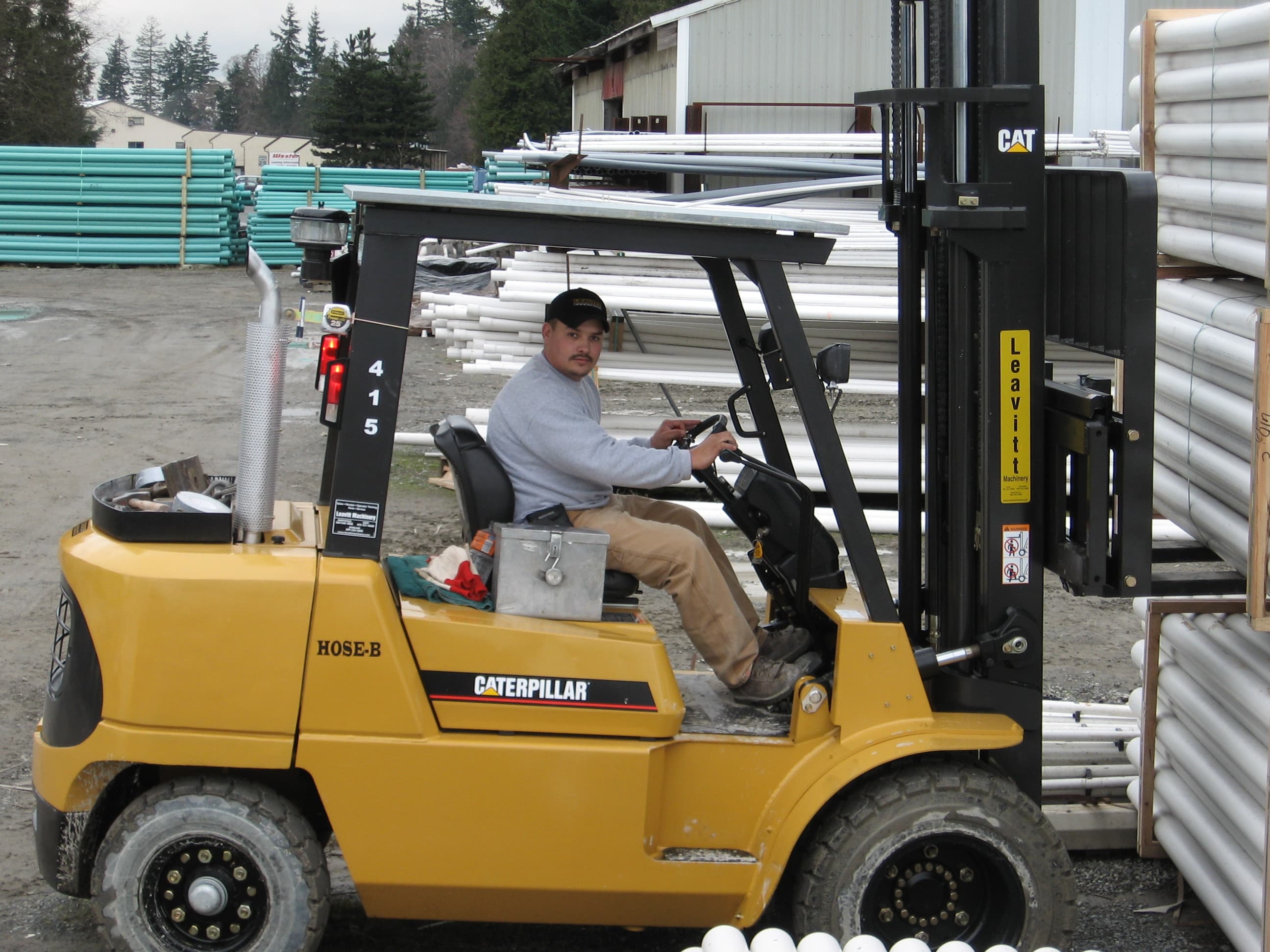 Worker operating a forklift in the Cuz Concrete yard