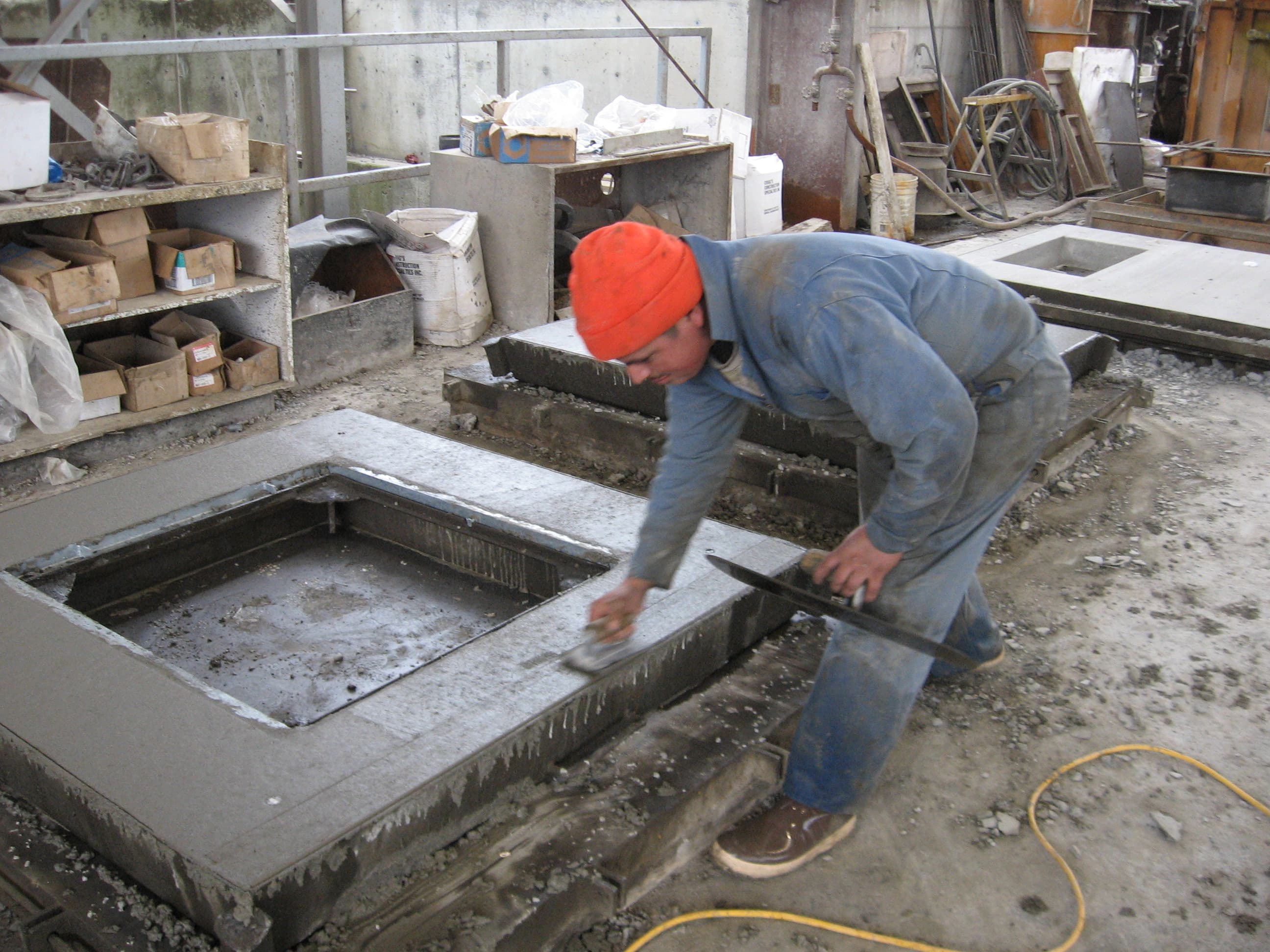 Worker finishing the surface of a wet precast concrete form