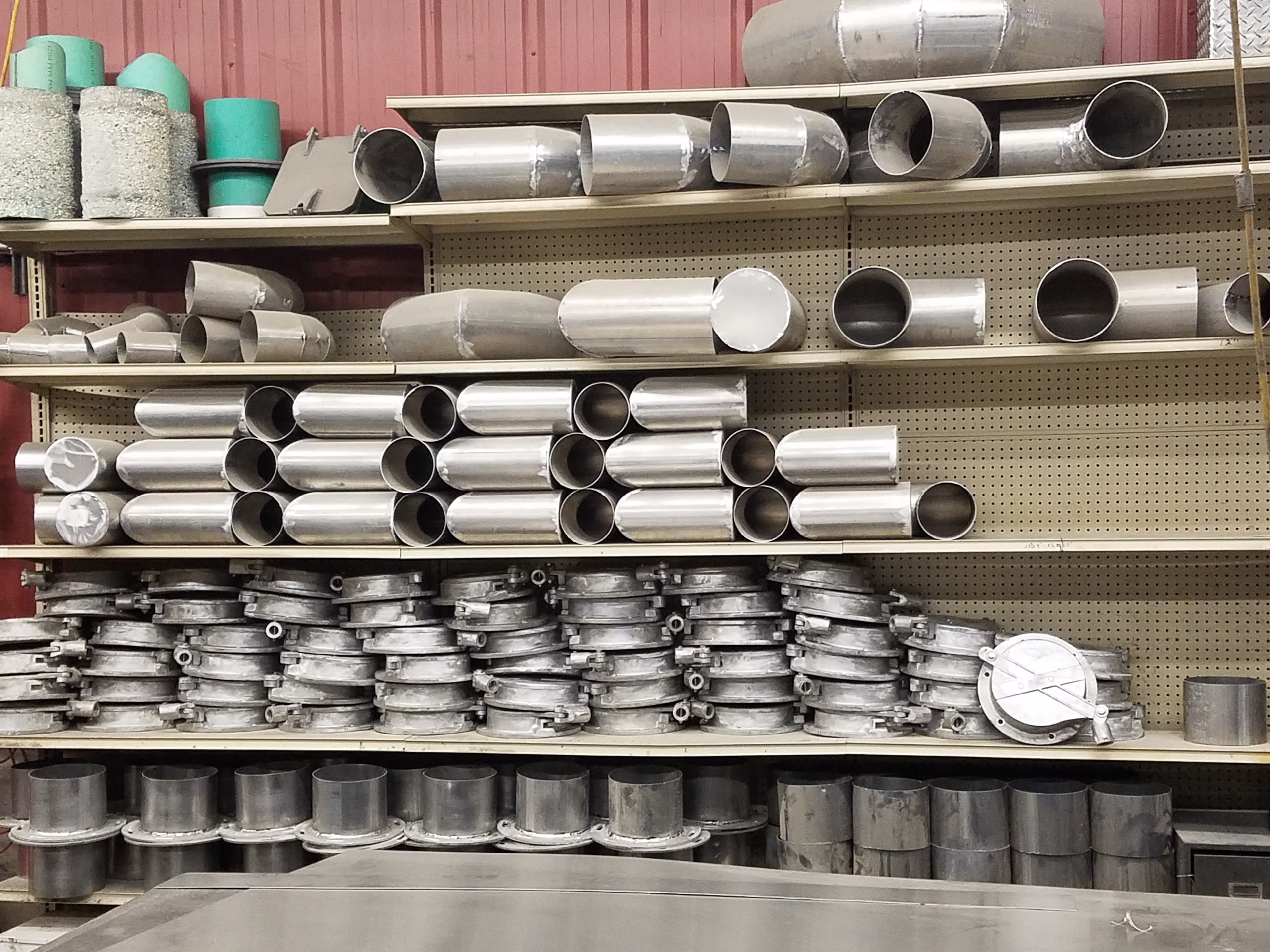 Metal pipes and fittings organized on workshop shelves