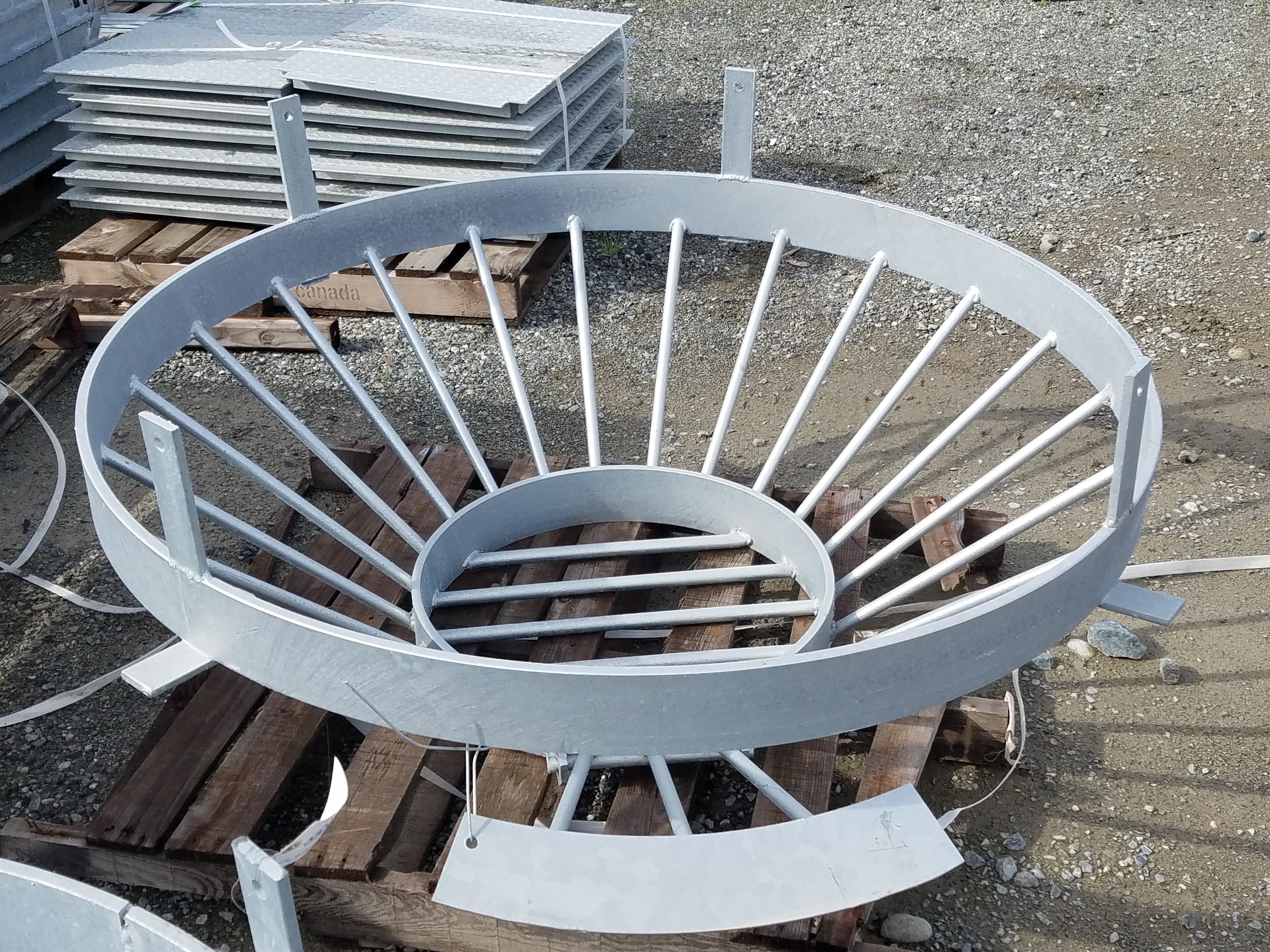 Circular metal structure with radial bars on wooden pallets